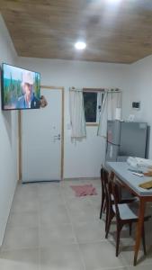 Cabaña La Escondida في تريليو: غرفة معيشة مع طاولة وتلفزيون على السقف