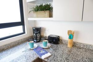 a kitchen counter with two cups and a coffee maker at Praiano San Marino in Harry Manzo