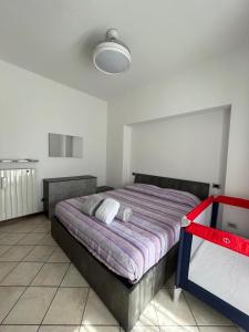 1 dormitorio con 1 cama con manta morada en Lake mood holiday home en Cadrezzate