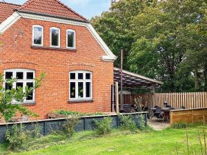 a red brick house with a garden in front of it at Holiday home Grindsted IV in Grindsted