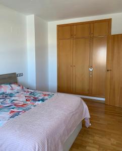 a bedroom with a bed and a wooden cabinet at Apartamento Torre Laguna in El Ejido