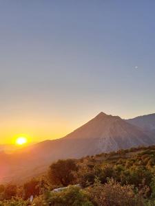 a view of a mountain with the sun setting behind it at Bujtina KOEL in Gjirokastër