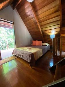 a bedroom with a bed in a room with wooden ceilings at Cabaña de Montaña Flaki's in Monteverde Costa Rica