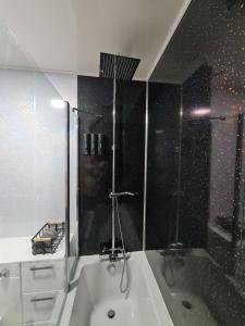 een badkamer met douche en ligbad bij City Centre Apartment in Aberdeen