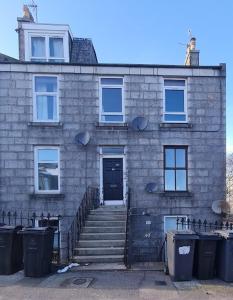 een bakstenen gebouw met een trap naar een deur bij City Centre Apartment in Aberdeen