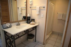 a bathroom with a sink and a mirror and a shower at La Concha Beach Hotel & Club in La Paz