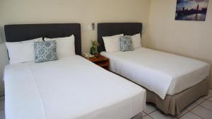 two beds in a hotel room next to each other at La Concha Beach Hotel & Club in La Paz