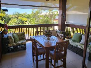 a porch with a table and chairs and a couch at "Simplesmente um Paraíso" in Praia do Forte