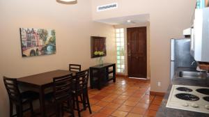 a kitchen with a table and chairs and a refrigerator at La Concha Beach Hotel & Club in La Paz