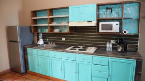 a kitchen with blue cabinets and a refrigerator at La Concha Beach Hotel & Club in La Paz