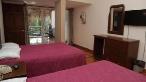 a bedroom with two beds and a mirror and a dresser at La Concha Beach Hotel & Club in La Paz