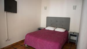 a bedroom with a bed and a flat screen tv at La Concha Beach Hotel & Club in La Paz