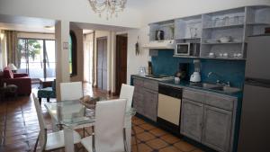 a kitchen and dining room with a glass table at La Concha Beach Hotel & Club in La Paz