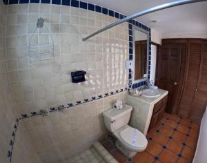 a bathroom with a toilet and a sink at La Concha Beach Hotel & Club in La Paz
