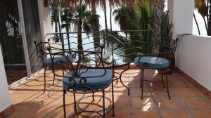 a table and chairs on a patio with plants at La Concha Beach Hotel & Club in La Paz