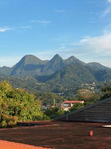 a view of mountains from the roof of a house at La Porte Du Paradis in Fort-de-France