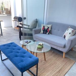 un salon avec un canapé bleu et une table en verre dans l'établissement Departamento de Playa en Punta Hermosa, à Punta Hermosa