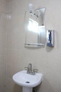 a bathroom with a sink and a mirror at Amplia Casa/Residencia a 15 Minutos de playa Miramar y Altama in Tampico