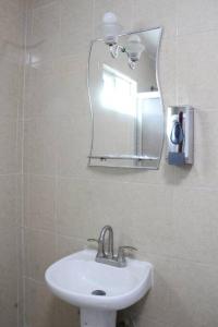 a bathroom with a sink and a mirror at Conexión Perfecta Entre Playa y Aviones in Tampico