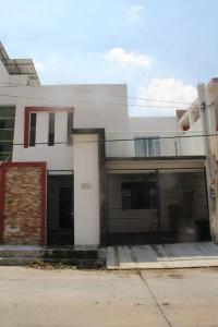 um edifício branco com duas portas de garagem e um edifício em Amplia Casa/Residencia a 15 Minutos de playa Miramar y Altama em Tampico