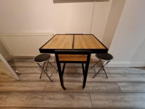 een houten tafel met 2 stoelen in een kamer bij City Centre Apartment in Aberdeen