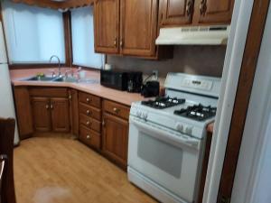 a kitchen with a white stove and wooden cabinets at The Lodge@ Kendon in Lansing