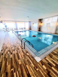 una grande piscina in un edificio con pavimento in legno di فندق كوخ الضباب النماص a Al Namas