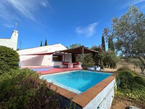 a swimming pool in front of a house at Courela do Monte Novo in Monte de Jangeis de Cima