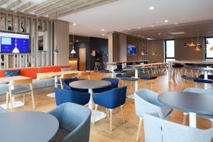 a restaurant with tables and chairs and a tv at Holiday Inn Express - Remscheid in Remscheid