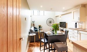 a kitchen and dining room with a table in a room at Fresh and Luxurious Stylish, Grade II Listed Church conversion with Workspace, centrally located in Stow on the Wold