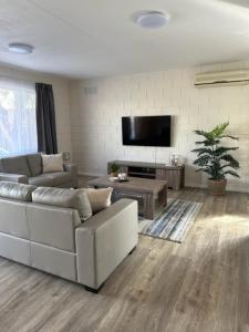 a living room with a couch and a flat screen tv at Harbour View 49 Urch Street Unit 8 in Geraldton