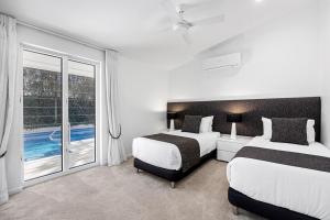 Un dormitorio con dos camas y una gran ventana. en Family & Pet-Friendly Luxury Near Hastings St, en Noosa Heads 32 fotos más