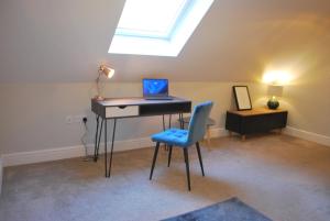 a room with a desk with a laptop and a chair at Stylish Hampshire Cottage, Parking, Patio, Dog Friendly, Local Restaurants in Fleet