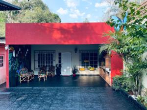 a red and white house with a red wall at Tu hogar en las cataratas in Puerto Iguazú