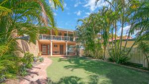 an exterior view of a house with palm trees at The Point in Iluka
