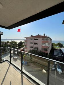 een balkon met uitzicht op een gebouw en een rode vlag bij Lake & sea view 2 bedrooms apartments in Istanbul