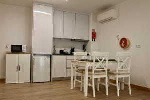 a kitchen with a table and chairs and a refrigerator at Plátanos & River Apartments by Lethes Legacy in Ponte de Lima