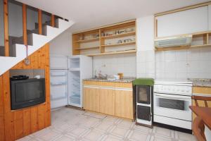 eine Küche mit weißen Geräten und einem TV in der Unterkunft Apartments by the sea Unesic - Unije, Losinj - 8044 in Unije