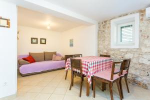 sala de estar con mesa y sofá en Holiday house with a parking space Igrane, Makarska - 8332 en Igrane
