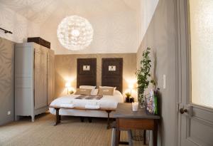 a bedroom with a bed and a chandelier at Il Etait Une Fois Chez Moi La Chambre Augustin in Le Loroux-Bottereau