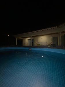a swimming pool at night with a house at Casa das Laranjeiras in Alqueidão da Serra