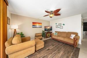 - un salon avec deux canapés et un ventilateur de plafond dans l'établissement Big Island Kona Makai 4205 condo, à Kailua-Kona