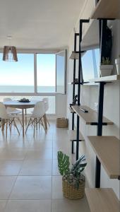 a living room with a staircase and a table and chairs at Excelente! 4 personas frente al mar con cochera in Mar del Plata