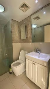 y baño con aseo, lavabo y ducha. en Calyx Residences City View en Cebu City