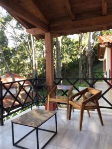 een patio met stoelen en tafels op een veranda bij Cabaña Lunamiel 3 in Mazamitla