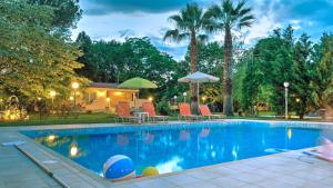 a swimming pool with chairs and umbrellas in a yard at Villa Vivere in Corfu Town