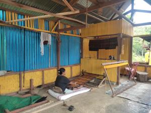 eine Person arbeitet an einer Wand in einem Raum in der Unterkunft Lawi Luja Guest House in Kelimutu
