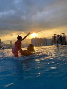 dos niños jugando en el agua en una piscina en Calyx Residences City View en Cebu City