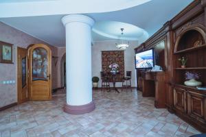 une grande chambre avec une colonne blanche et une télévision dans l'établissement Luxuria Central Villa Bucharest, à Bucarest
