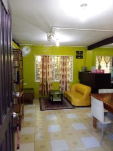 Island Home في هونيارا: غرفة معيشة بجدران خضراء وأريكة صفراء